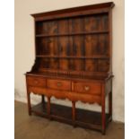 An 18th century oak South Wales dresser with a moulded cornice above two shelves,