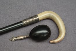 A silver and horn handled walking stick together with a white metal handled item