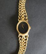 An 18ct gold Baume and Mercer lady's wristwatch, with an oval dial and integral strap,