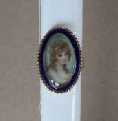 An 18ct gold portrait ring of oval form with blue enamel border painted with the head and shoulders
