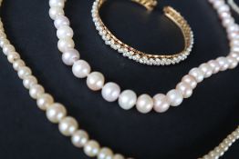 A pearl necklace with graduated beads,to a yellow metal clasp,