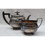 A late Victorian silver teapot and matching twin handled sugar basket, with an oval ribbed body,