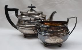 A late Victorian silver teapot and matching twin handled sugar basket, with an oval ribbed body,