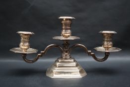 An Elizabeth II silver twin branch candelabra with turned sconce and scrolling arms on a stepped