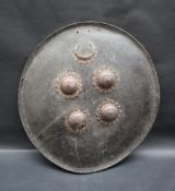 A leather shield of circular domed form with an applied copper crescent and four copper domes,