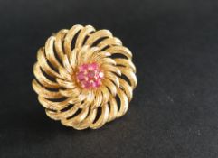An 18ct yellow gold brooch of circular floral form set with seven round faceted rubies to the