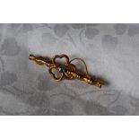 A 9ct gold faux bamboo bar brooch with central shamrock and green stone, approximately 1.