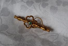 A 9ct gold faux bamboo bar brooch with central shamrock and green stone, approximately 1.