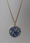 An 18ct gold lapis lazuli set pendant of circular form with geometric decoration,