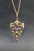 An Edwardian 9ct gold amethyst and seed pearl pendant on a yellow metal chain, approximately 6.