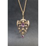 An Edwardian 9ct gold amethyst and seed pearl pendant on a yellow metal chain, approximately 6.