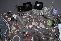 A large quantity of costume jewellery including brooches, pearl and semi precious stone necklaces,