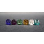 A 19th century cased set of six intaglio coloured-glass seals, with a faceted amber glass handle,