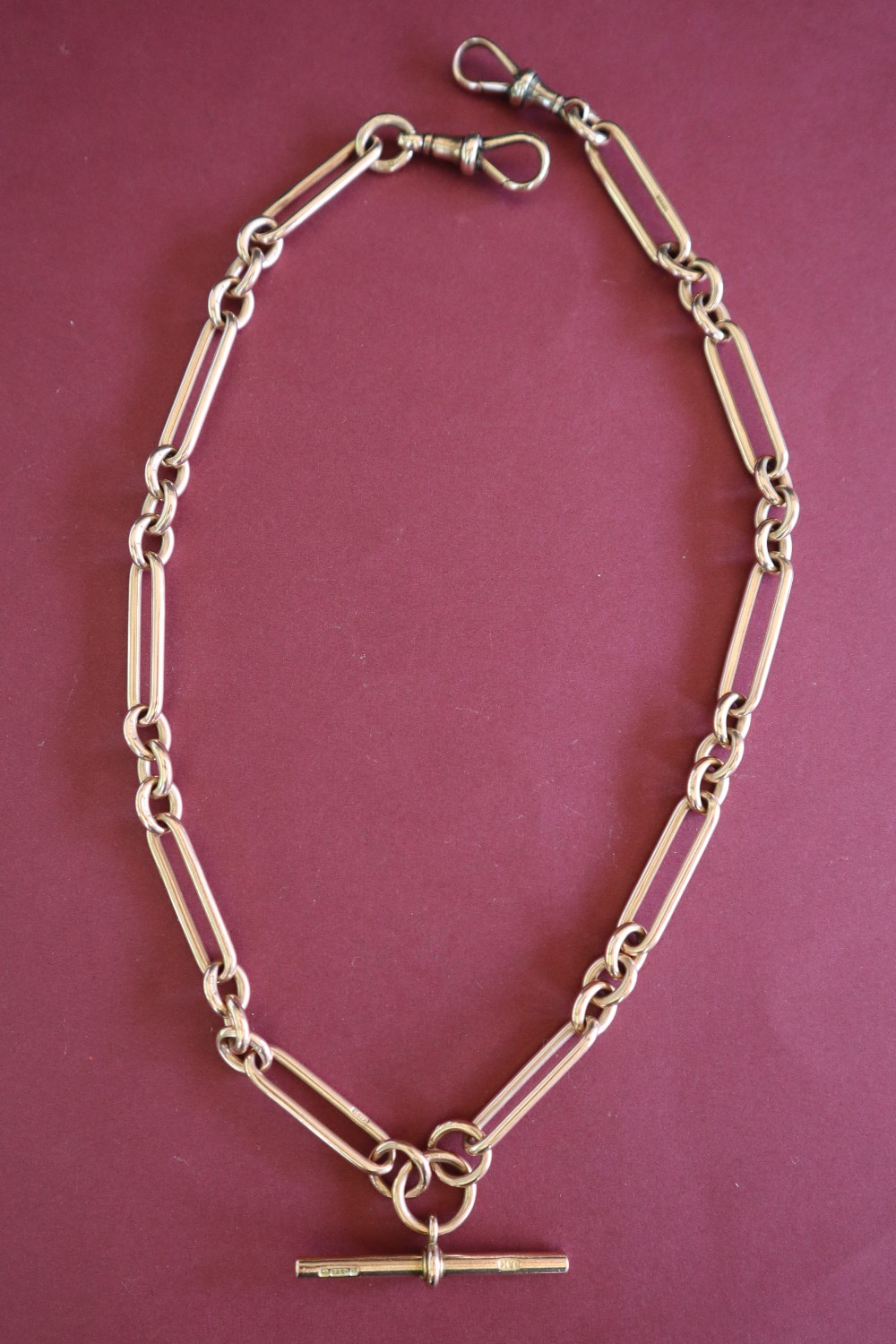 A 9ct yellow gold double albert watch chain with oval and circular links with a central T bar,