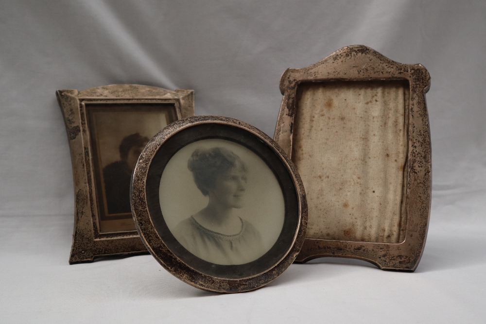 A silver photograph frame of shaped rectangular form together with two other silver photograph