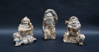 A set of three Japanese satsuma pottery figures of dignitaries, one standing the other two seated,