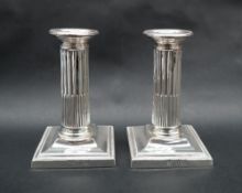 A pair of late Victorian silver corinthian column stop fluted candlesticks, on square bases, London,