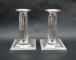 A pair of late Victorian silver corinthian column stop fluted candlesticks, on square bases, London,