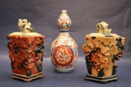 A pair of Chinese soapstone vases and covers decorated with fruiting vines,