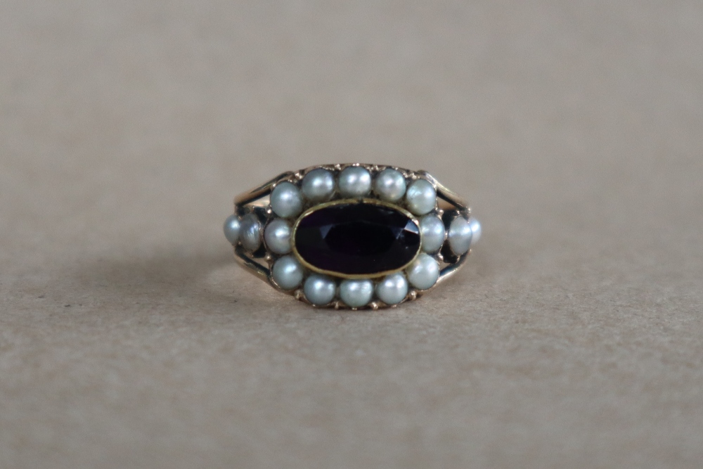 A late George III mourning ring set with a central oval faceted amethyst surrounded by half section - Image 2 of 6