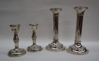 A pair of George V silver desk candlesticks, with ring turned columns on a spreading foot,