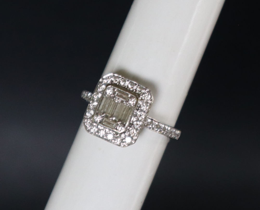 An 18ct white gold diamond cluster ring set with baguette and round brilliant cut diamonds to the