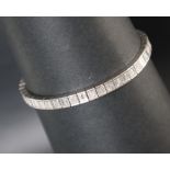 A white metal diamond set tennis bracelet,