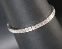 A white metal diamond set tennis bracelet,