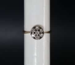 An 18ct yellow gold and platinum daisy ring, set with seven old round cut diamonds, size P,