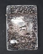 An Edwardian silver card carrying case with embossed decoration of a stag and scrolling leaves,