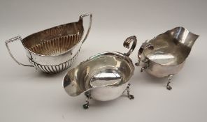 A pair of late Victorian silver sauce boats with a shaped rim and leaf capped scrolling handle,
