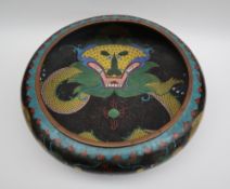 A Japanese cloisonne enamel bowl, decorated to the centre with a dragon to a black cloud ground,