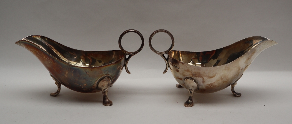 A pair of George VI silver sauce boats of usual form with ring handle and three legs with pointed