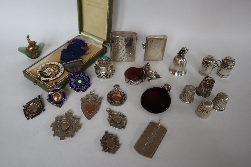 Silver vesta cases together with silver thimbles, a silver ingot pendant,