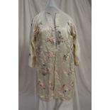 A Japanese silk kimono, the cream ground embroidered with roses and chrysanthemums,