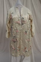 A Japanese silk kimono, the cream ground embroidered with roses and chrysanthemums,