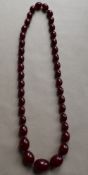 A Cherry Amber/ Cherry Bakelite long string of graduated beads,