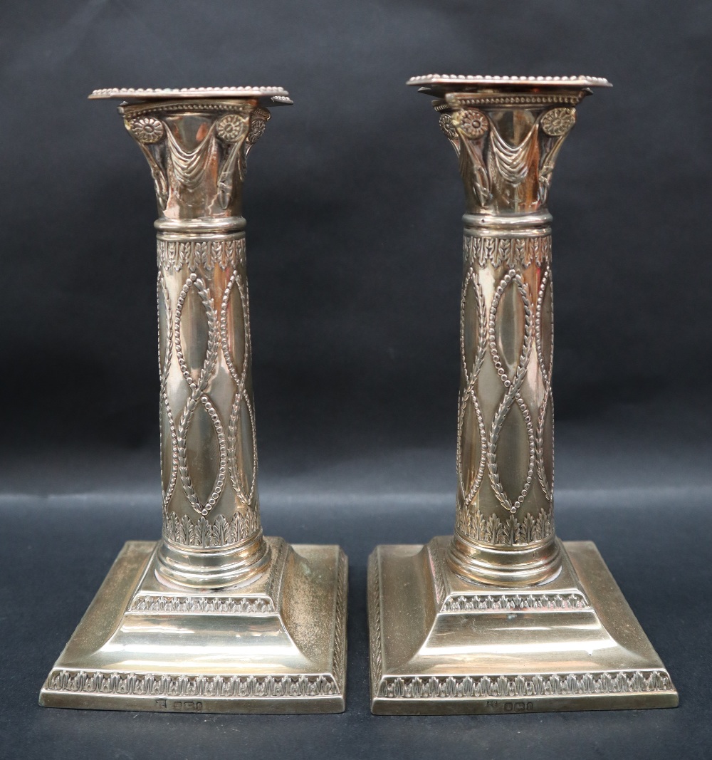 A pair of George V silver corinthian column candlesticks,