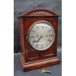 A late 19th / early 20th century oak bracket clock, with a domed top and pedestal base,