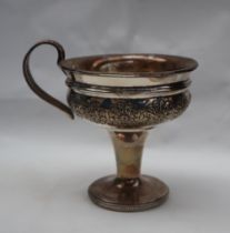 A George V silver pedestal cup, with a flared rim and floral border on a spreading foot,