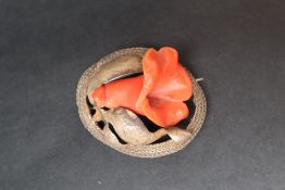 A gilt metal and coral brooch in the form of a flower in bloom,