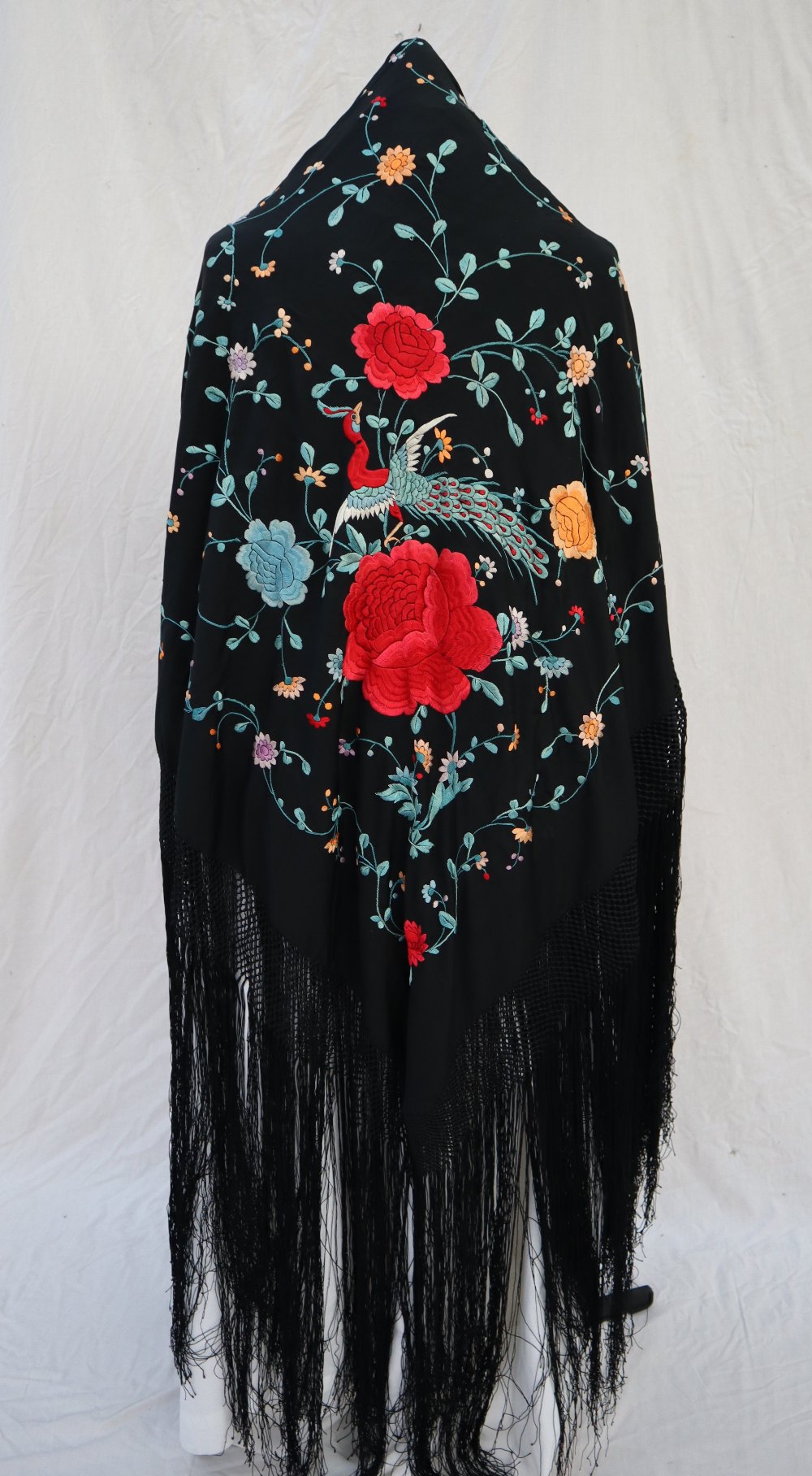 A silk piano shawl, the black ground profusely embroidered with peacocks,