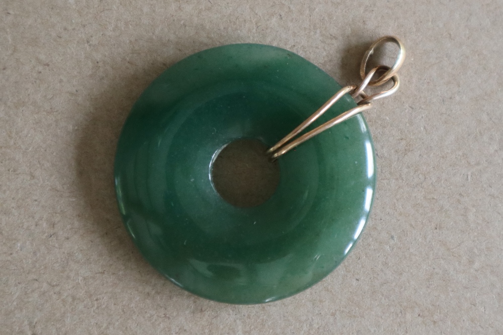 A green jade pendant of circular ring form, 4cm diameter on a yellow metal mount, - Image 3 of 3