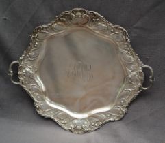 American Silver - A Sterling silver twin handled tray with a scrolling leaf and flowerhead border,