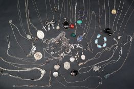 A collection of silver necklaces with various pendants set with semi precious stones and enamelled