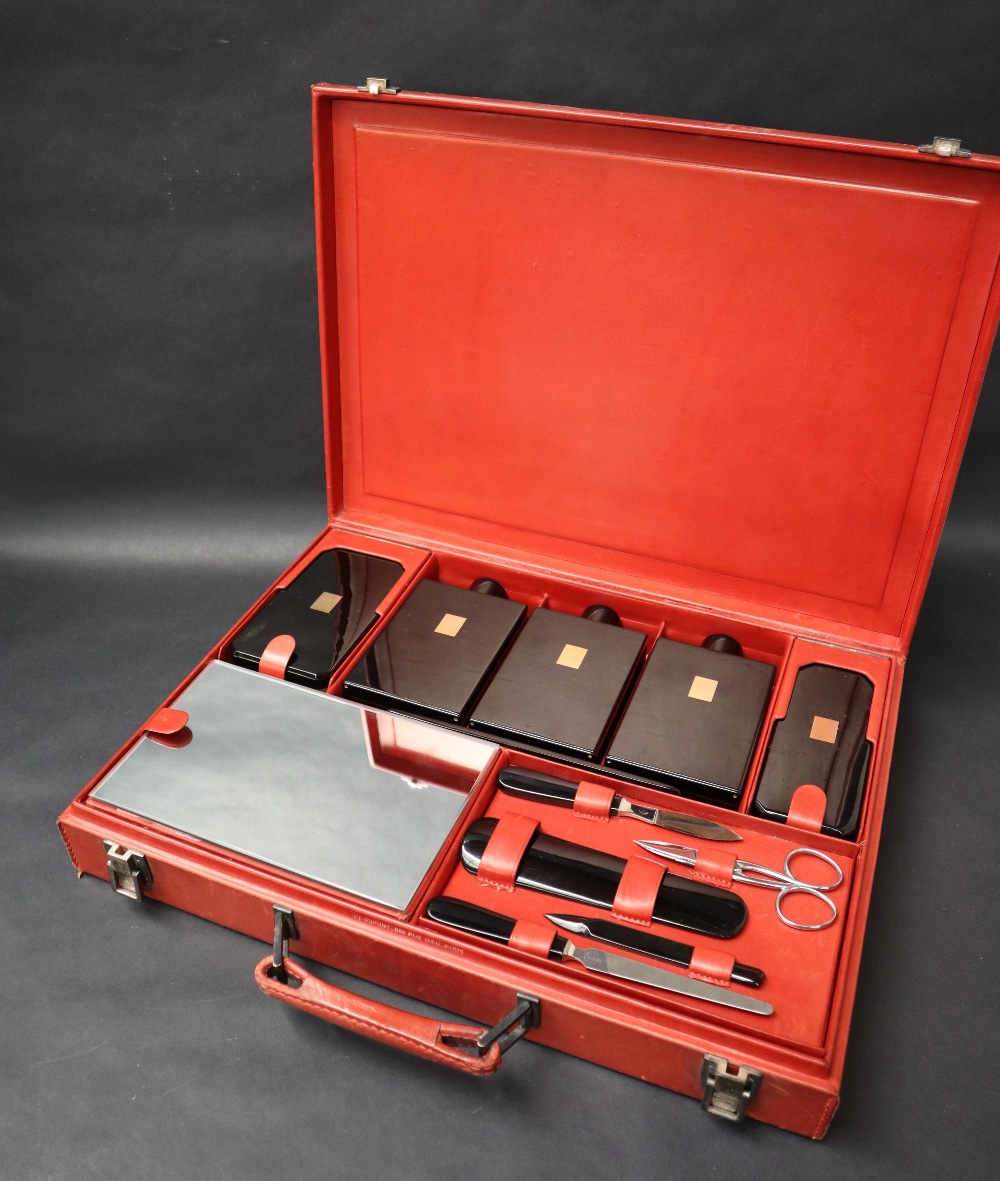 S T Dupont, a red leather travelling case fitted with two brushes, three bottles, easel mirror,
