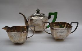 A white metal three piece tea set in the Art Deco style, decorated with geometric patterns,