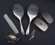 A silver backed matched part dressing table set comprising two hair brushes,