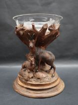 A Swiss carved table centrepiece with a glass bowl raised on a carved tree stump decorated with