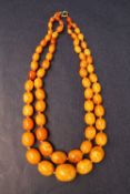 A double string of oval amber beads,smallest bead approximately 9mm x 7mm,